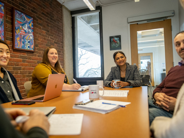 Four researchers gathered around a table, talking