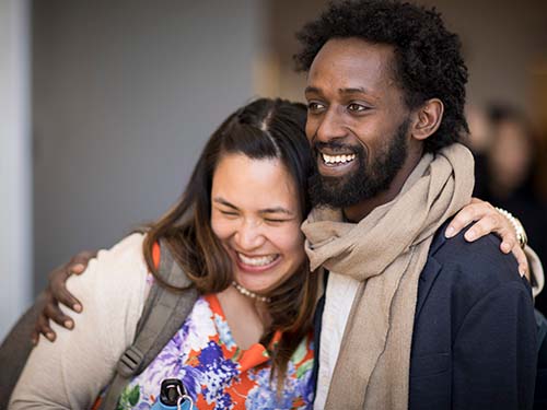 two SID students smiling and hugging